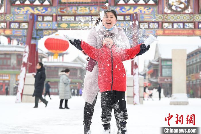 2月13日，家長與小朋友在呼和浩特市大召廣場享雪趣?！⑽娜A 攝