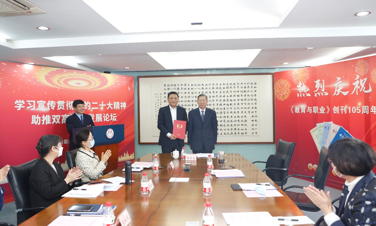 郝明金為《教育與職業(yè)》雜志編委代表陳曉明頒發(fā)聘書。中華職教社供圖
