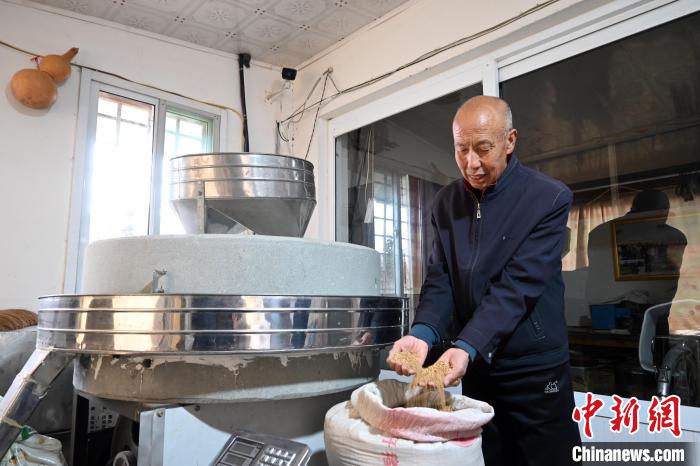 李家莊村民谷文朝重拾父輩的手藝，做起石磨面粉的營(yíng)生?！〉杂鸺?攝