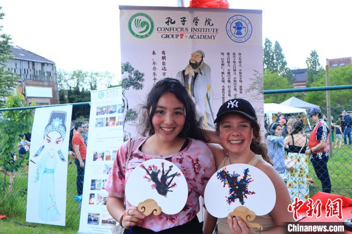 孩子們展示自己的吹墨畫團扇作品。　魯汶孔子學院供圖