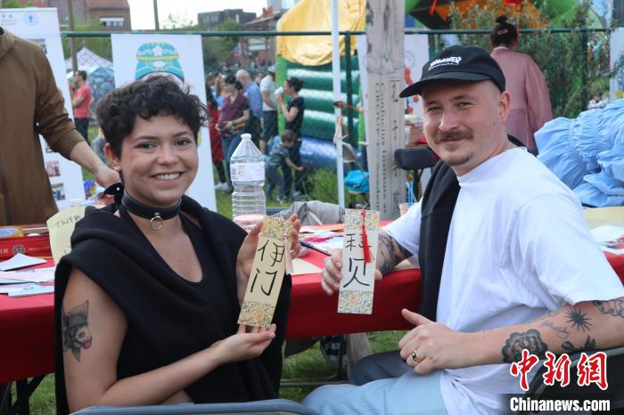 當?shù)孛癖娫跐h字體驗工作坊展示自己手寫的中文名書簽。　魯汶孔子學院供圖