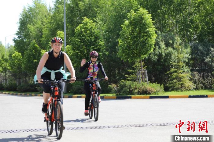 亞信副秘書長遲方(右一)與聯(lián)合國駐哈協(xié)調(diào)員在騎行活動(dòng)中?！喰琶貢幑﹫D