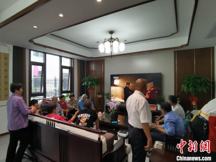 親友們集中在費(fèi)俊龍家中觀看返程的視頻?！＄娚?攝