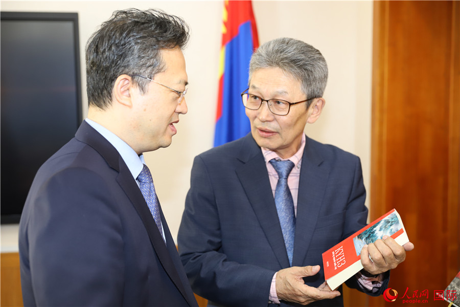 其米德策耶（右一）向李峙介紹翻譯成果。人民網(wǎng)記者 霍文攝