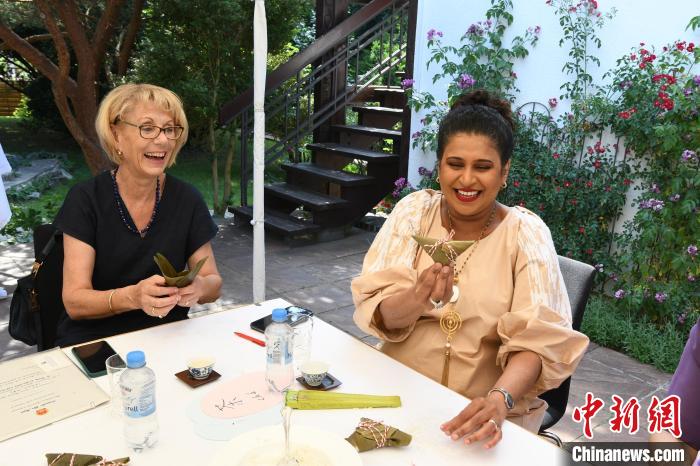 圖為嘉賓展示包粽子成果?！“亓种袊?guó)文化中心供圖。