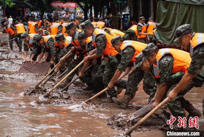 7月4日，萬(wàn)州區(qū)五橋街道，武警官兵清理街道上的淤泥?！∪矫宪?攝
