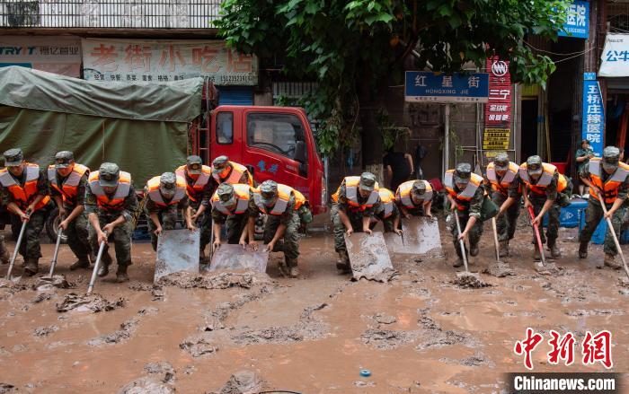 7月4日，萬(wàn)州區(qū)五橋街道，武警官兵清理街道上的淤泥?！∪矫宪?攝
