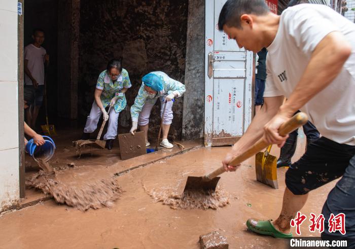 7月4日，萬(wàn)州區(qū)五橋街道，洪水退去后，居民開(kāi)展清淤工作。　冉孟軍 攝