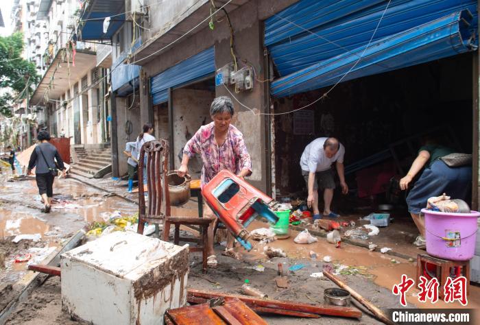 7月4日，萬(wàn)州區(qū)五橋街道，洪水退去后，居民搶救生活物資?！∪矫宪?攝