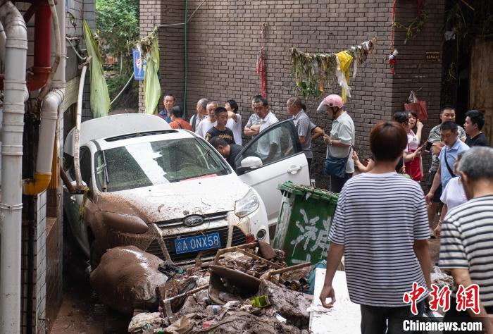 7月4日，萬(wàn)州區(qū)五橋街道，居民救援受困的私家車?！∪矫宪?攝