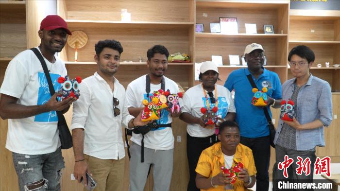 圖為國(guó)際青年代表展示親手制作的東營(yíng)非遺黃河口布偶 ?！↓R魯 攝