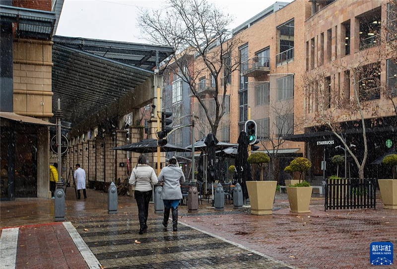 7月10日，在南非約翰內(nèi)斯堡一處商業(yè)區(qū)，人們?cè)谘┲行凶摺Ｐ氯A社記者 張譽(yù)東 攝