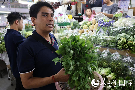 7月19日，泰國曼谷藍(lán)象餐廳員工向參加活動(dòng)的多國代表介紹如何挑選新鮮蔬菜。 人民網(wǎng)記者 張矜若攝