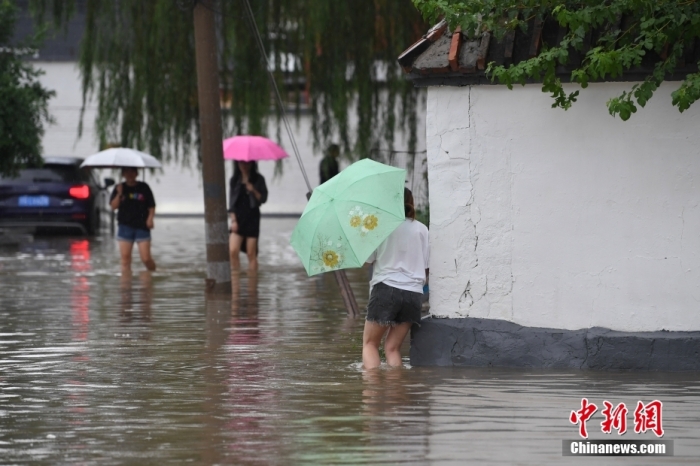7月31日，市民行走在雨中的北京房山區(qū)瓦窯頭村。北京市氣象臺當日10時發(fā)布分區(qū)域暴雨紅色預警信號。北京市水文總站發(fā)布洪水紅色預警，預計當日12時至14時，房山區(qū)大石河流域?qū)⒊霈F(xiàn)紅色預警標準洪水。<a target='_blank' href='/'><p  align=