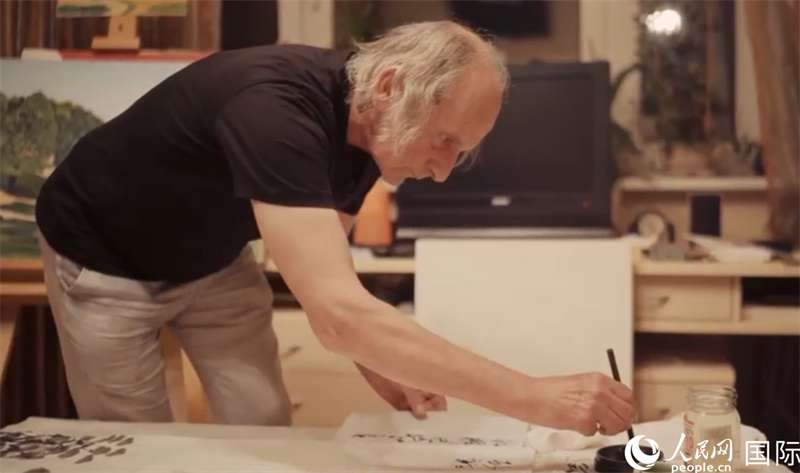 伊戈爾·布爾東諾夫在畫作上題詞。人民網(wǎng)記者 馬天翼攝