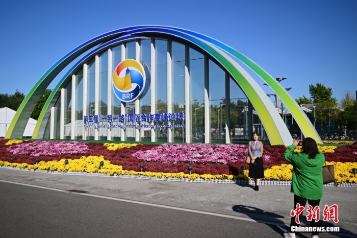 10月15日，北京，工作人員在國(guó)家會(huì)議中心外的第三屆“一帶一路”國(guó)際合作高峰論壇景觀布置前拍照留念。當(dāng)日，位于國(guó)家會(huì)議中心的第三屆“一帶一路”國(guó)際合作高峰論壇新聞中心啟動(dòng)試運(yùn)行。據(jù)悉，第三屆“一帶一路”國(guó)際合作高峰論壇將于10月17日至18日在北京舉行。<a target='_blank' href='/'><p  align=