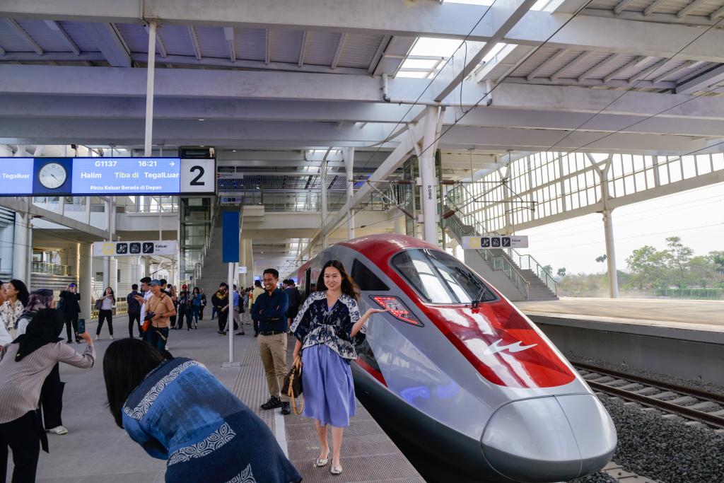 10月17日，在印度尼西亞萬隆德卡魯爾站，乘客在站臺上和雅萬高鐵高速動車組列車合影。