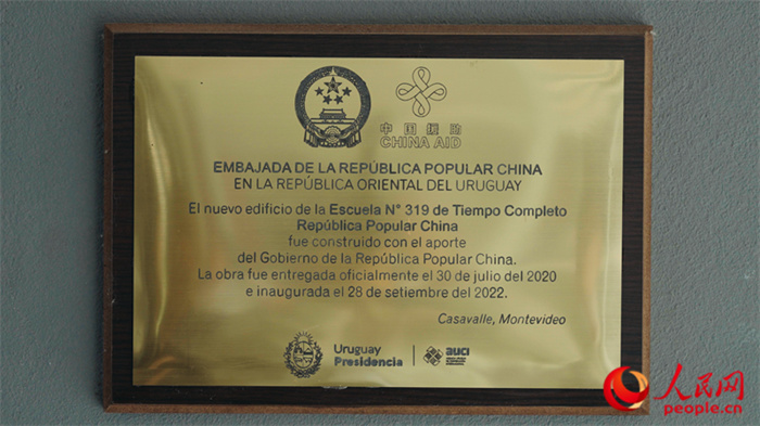 小學(xué)墻上懸掛的中國援助標識。人民網(wǎng)記者 張若涵攝