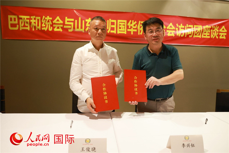 中國僑聯(lián)副主席、山東省僑聯(lián)主席李興鈺（右）與巴西和統(tǒng)會(huì)會(huì)長王俊曉簽署合作協(xié)議書。人民網(wǎng)記者 陳海琪攝