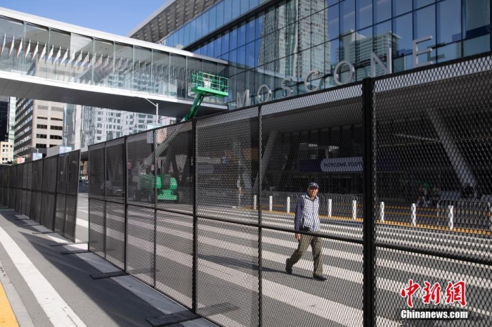 當(dāng)?shù)貢r間11月10日，一名行人從美國舊金山莫斯康中心周圍的金屬圍欄旁經(jīng)過。隨著亞太經(jīng)合組織(APEC)第三十次領(lǐng)導(dǎo)人非正式會議臨近，作為會議場地的莫斯康中心附近出現(xiàn)金屬圍欄，執(zhí)勤警察也大幅增加。<a target='_blank' href='/'><p  align=