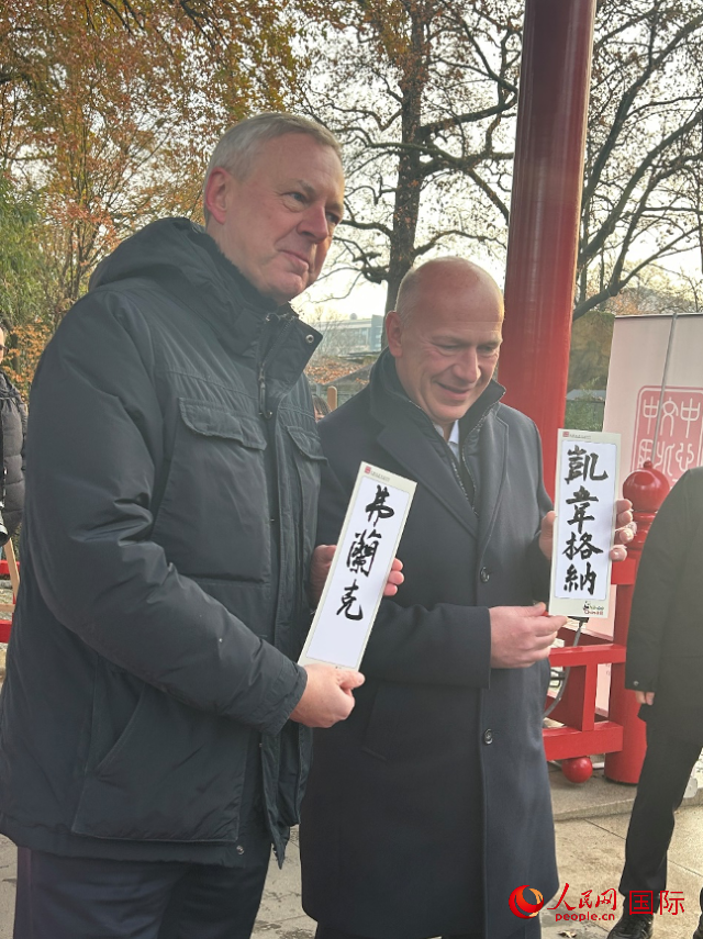 柏林市長韋格納（右）、動(dòng)物園監(jiān)事會(huì)主席布魯克曼（左）手持中國文化中心工作人員現(xiàn)場(chǎng)手書的中文名字。人民網(wǎng)記者 徐馨攝