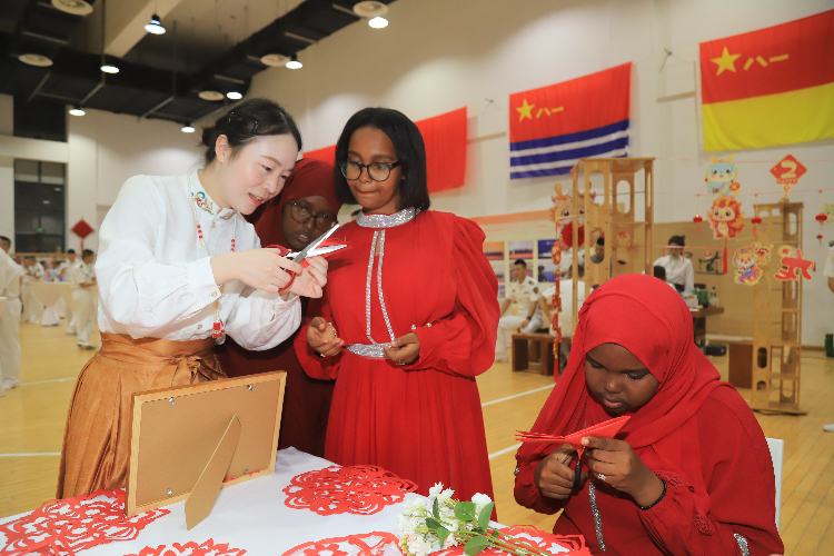 中國(guó)剪紙藝術(shù)吸引當(dāng)?shù)厝耸繀⑴c體驗(yàn)。陳錦俊攝