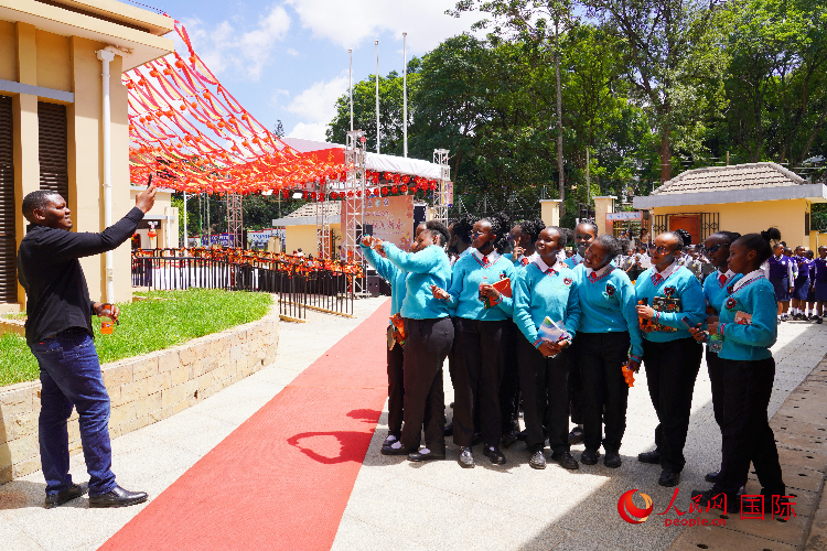 一名老師在給學(xué)生拍照留念。人民網(wǎng)記者 黃煒鑫攝