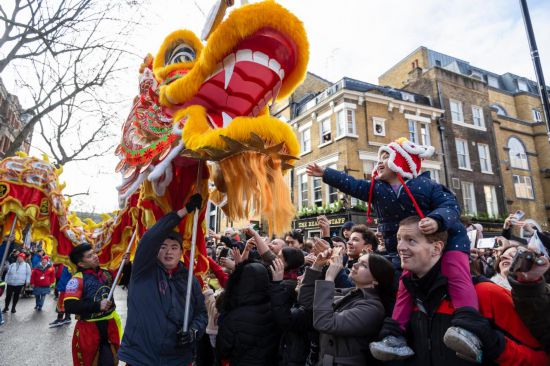 2月11日，人們在英國倫敦的新春巡游活動中觀看舞龍表演。新華社發(fā)（史蒂芬·程攝）