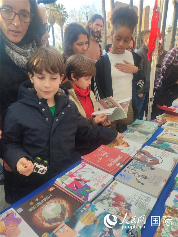 印刷精美的中國傳統(tǒng)文化叢書吸引了小游客的注意。人民網(wǎng)記者鄭彬攝