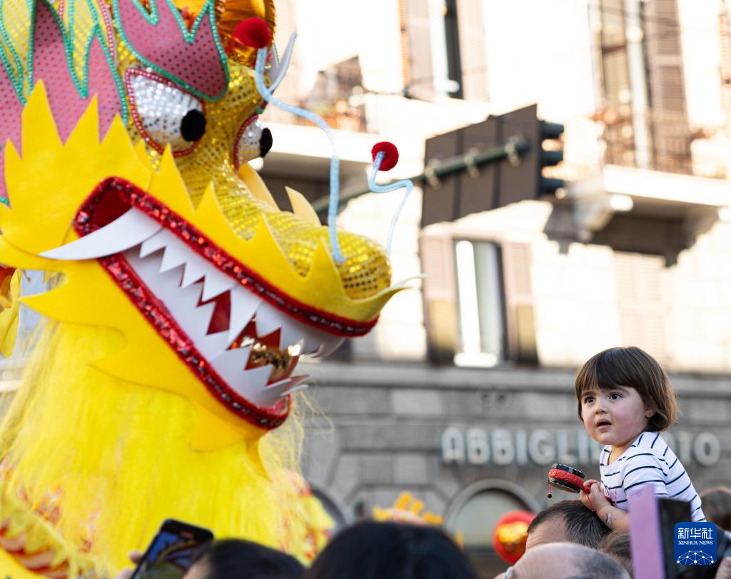 2月18日，在意大利羅馬，一名小朋友在彩妝巡游上觀看舞龍。新華社記者 李京 攝