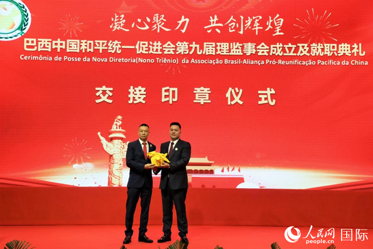 就職典禮中，巴西和統(tǒng)會第七屆和第八屆會長王俊曉與新任會長張小春交接印章。人民網(wǎng)記者 時元皓攝