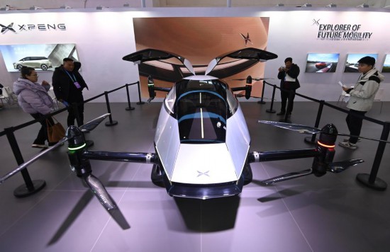 2023年12月1日，在鏈博會智能汽車鏈展區(qū)小鵬汽車展臺，參觀者觀看一臺智能飛行器。新華社記者蔡湘鑫攝
