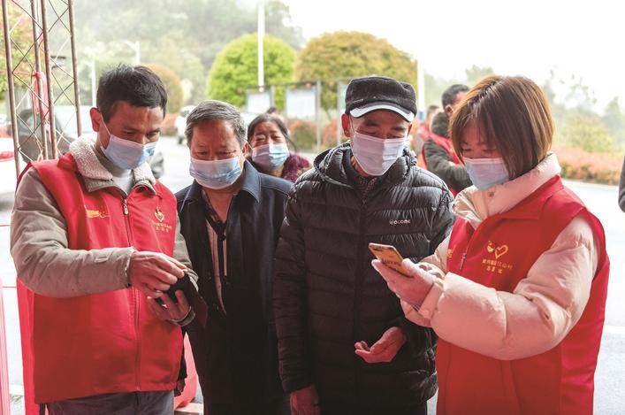 長沙縣黨員志愿者正在幫助參與核酸檢測的群眾掃描“場所碼”。劉思源 攝