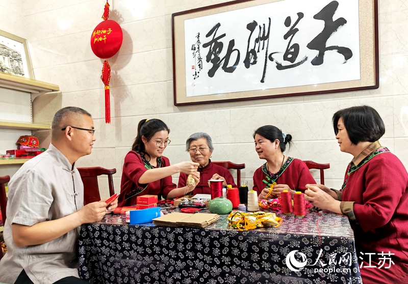 王秀英老人指導(dǎo)孫女制作香包。人民網(wǎng) 閆峰攝