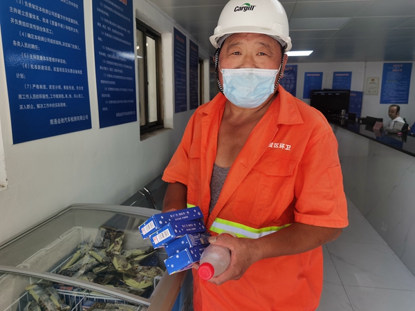 1環(huán)衛(wèi)工倪建宏小憩后，為還同事帶去冷飲。人民網(wǎng)記者王繼亮攝