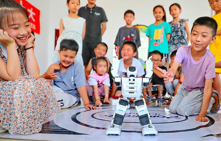 2022年7月19日，河北省秦皇島市海港區(qū)白塔嶺街道秦皇半島第二社區(qū)內(nèi)，小朋友正在觀看“機器人跳舞”。 曹建雄攝