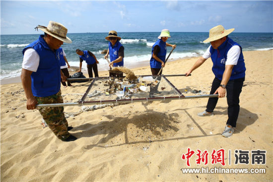 環(huán)保志愿者用篩網(wǎng)“淘”出海灘上的垃圾。