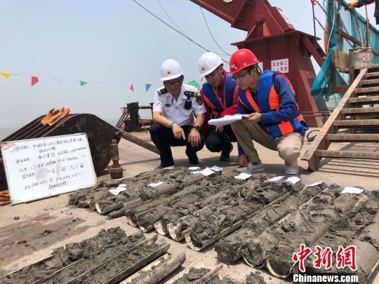 圖為勘察設(shè)計(jì)人員與海事局工作人員查看巖芯情況?！∥赫?攝