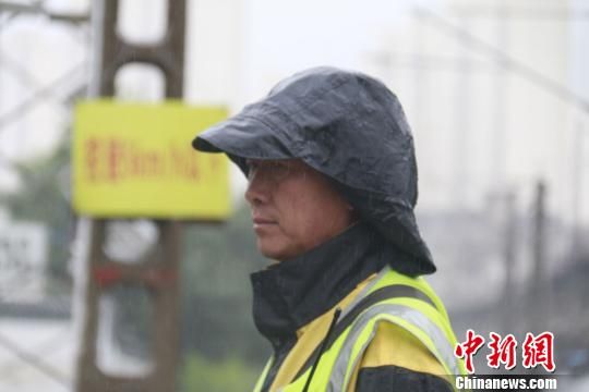蘭州西工務(wù)段蘭州線路車(chē)間防護(hù)員雨中巡查?！⊥豕廨x 攝