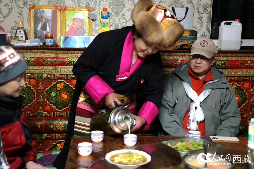 扎西曲登社區(qū)的居民在家中熱情招待遠(yuǎn)道而來(lái)的游客。居民身著盛裝，為游客倒上熱騰騰的酥油茶，桌上擺放著切瑪與特色美食，賓主共話民族團(tuán)結(jié)情誼。人民網(wǎng)記者 吳雨仁攝