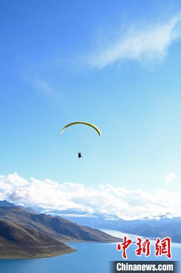 圖為在羊卓雍錯(cuò)，游客體驗(yàn)高空滑翔?！≮w朗 攝