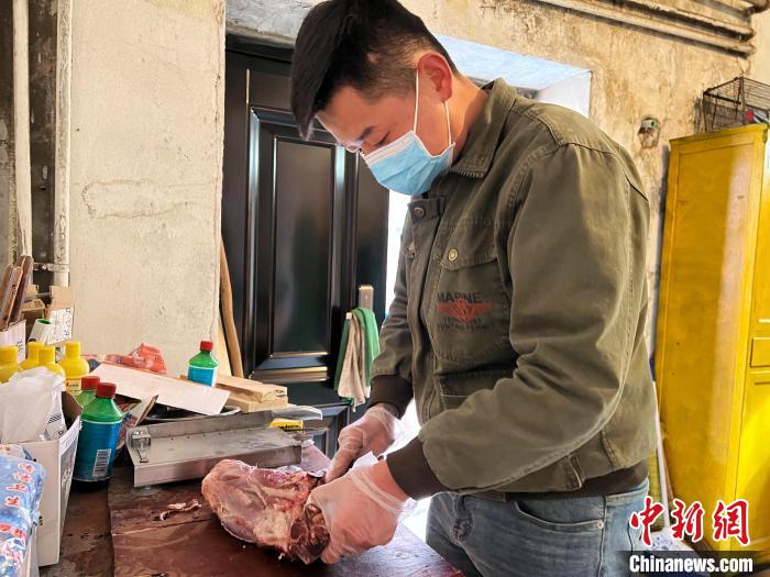 圖為雪豹“奶爸”史壽軍正在準備投喂雪豹的食材?！●R銘言 攝