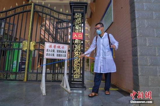 資料圖：?？诮?jīng)濟學院的工作人員在學生宿舍樓入口消毒。 中新社記者 駱云飛 攝