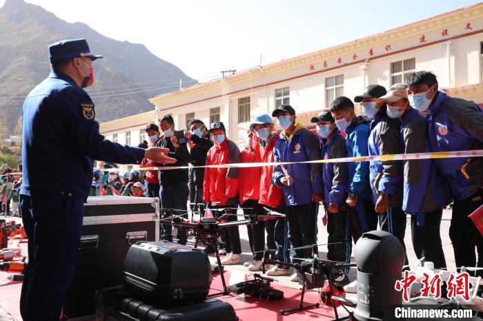 圖為消防指戰(zhàn)員為學(xué)生講解、演示先進(jìn)救援裝備。　趙琳 攝