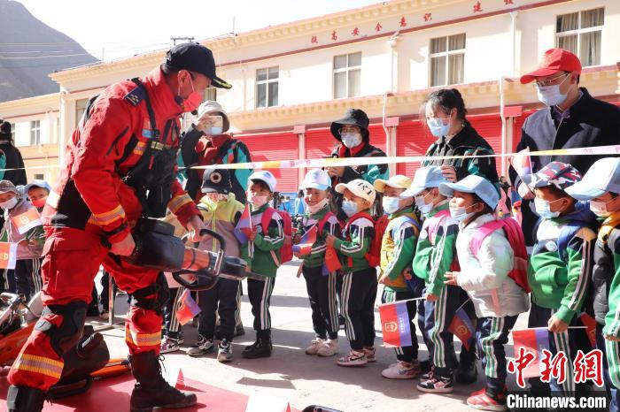 圖為消防指戰(zhàn)員為學(xué)生講解、演示先進(jìn)救援裝備?！≮w琳 攝