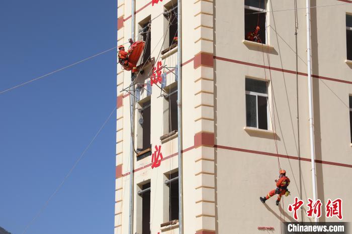 圖為消防指戰(zhàn)員進(jìn)行繩索救援演練。　朱科熹 攝