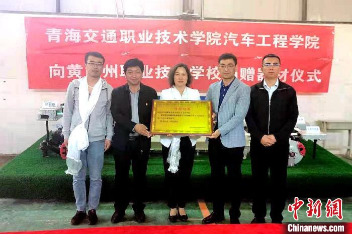 圖為李富香(中)代表學校為州縣技校捐贈器材。(資料圖) 青海省教育廳供圖