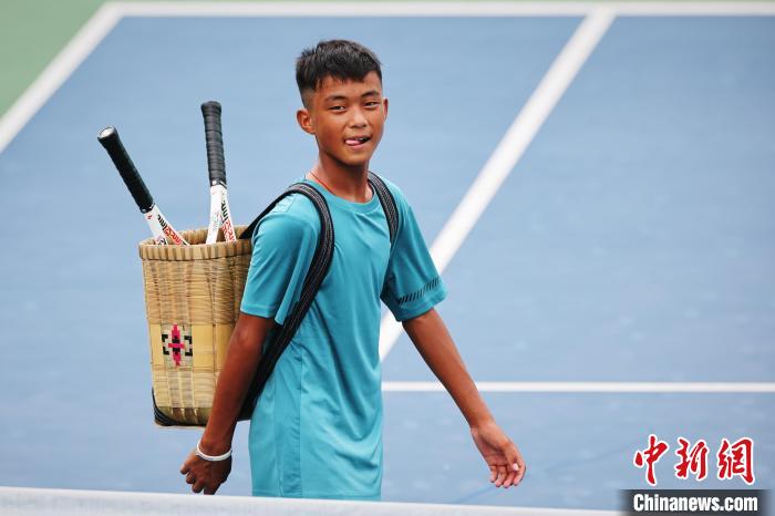 王發(fā)背著背簍在賽場上。　李建藝 攝