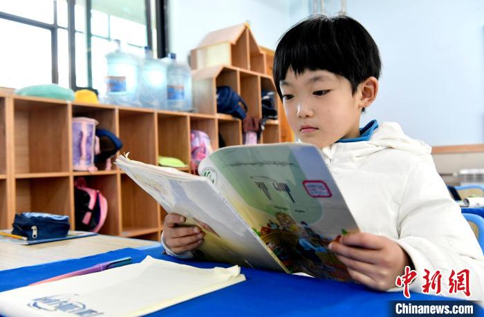 3月14日，西藏拉薩市第一小學(xué)一年級(jí)六班學(xué)生丁增樂吉在閱讀藏語課本?！±盍?攝