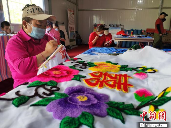 圖為婦女制作青繡?！?zhí)砀?攝